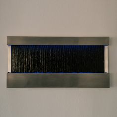 a wall mounted light that is on the side of a white wall with blue lights