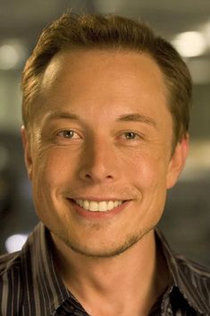 a close up of a person wearing a black and white shirt smiling at the camera