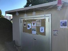 a small building with posters on the front and back wall, covered in snowflakes