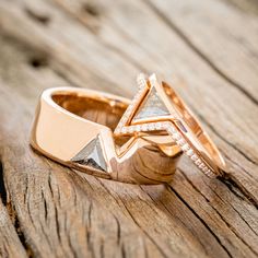 two gold wedding rings with diamond accents on wooden surface