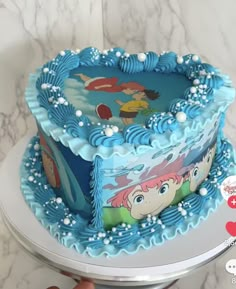 there is a blue cake with ariel the mermaid on it