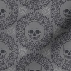 skulls and roses on grey background with black accents, in the center is a circular design