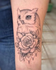 an owl and rose tattoo on the arm