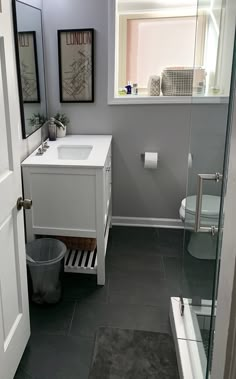 a white sink sitting under a bathroom window next to a toilet and bathtub in a bathroom