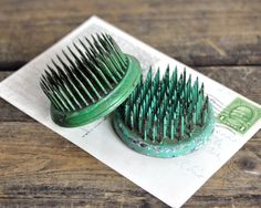 two green brushes sitting on top of a piece of paper next to each other,