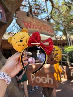 someone is holding up a winnie the pooh ears