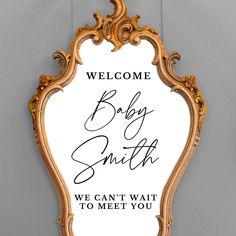 a welcome sign hanging on the side of a wall next to a mirror that says, baby smith we can't wait to meet you