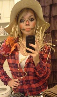 a woman wearing a scarecrow costume holding a cell phone