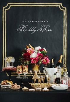 a table topped with lots of desserts and drinks next to a chalkboard sign