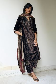 Bark brown kurta with floral block printed motifs and gold gota patti trim. Comes with co-ordinating salwar.
Component: 2
Print
Neckline: V neck
Sleeve Length: Three Fourth
Fabric: Velvet
Color: Brown
Side pockets
Gota patti trimmed salwar bottom, sleeve hems and neckline
Side slits
Closure: Hook front
Note: Dupatta worn by the model is not for sale - Aza Fashions Shorshe Clothing, V Neck Kurta, Velvet Kurta, Brown Velvet, Kurta With Pants, Velvet Color, Fashion App, Designer Gowns, Pant Set