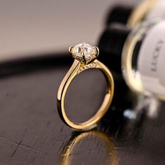 a diamond ring sitting on top of a table next to a bottle