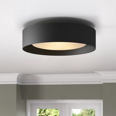 a black ceiling light hanging from the ceiling in a room with white walls and windows