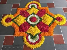 a colorful flower arrangement on the ground in front of a tiled floor with red, yellow and white flowers