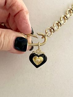 This shiny gold-plated cable chain necklace has a great weight to it. It connects to a gold rope design spring lock carabiner. The pendant is made of black enamel, pave stones, and a double heart in gold. The bale on the pendant is also encrusted in pave. This is a show-stopping necklace of modern and trendy design. The chain is lead-safe and nickel free. The chain's large link is 1/2 in and the middle link is 1/4 in. The Carabiner and chain is brass with 14k gold plating. The length of the neck Gold Charms For Necklace, Black And Gold Necklace, Carabiner Necklace, Kids Picnic, Necklace Charms, Cable Chain Necklace, Necklace Clasps, Heart Pendant Gold, Chunky Jewelry