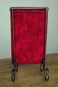 a red piece of cloth sitting on top of a metal rack