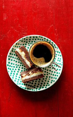 a cup of coffee and two pieces of cake on a plate