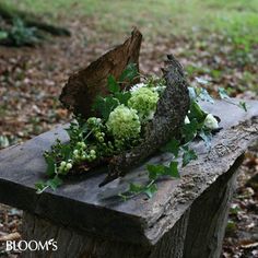 a wooden bench with flowers on it in the woods