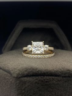 a princess cut diamond engagement ring with matching wedding band in a black velvet jewelry box