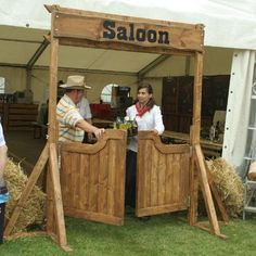 two people standing in front of a wooden stall