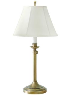 a gold lamp with a white shade on the base and a light bulb in the middle