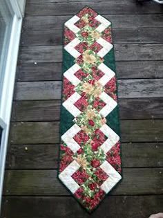 a green and red tie sitting on top of a wooden floor