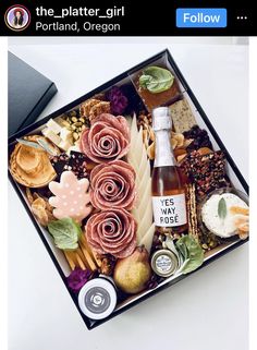 a box filled with different types of food and drinks on top of a white table