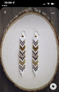 the beaded earrings are made from white, brown and black seed beads on a piece of wood