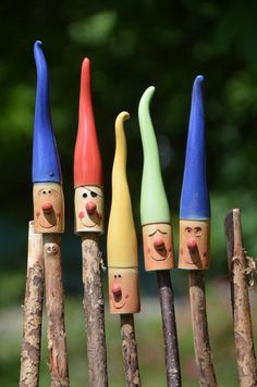 four wooden pegs with painted faces on them