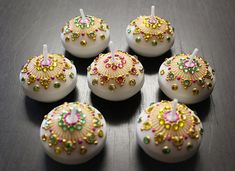 there are six candles that have been decorated with beads