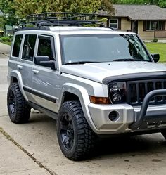 a silver jeep parked in front of a house