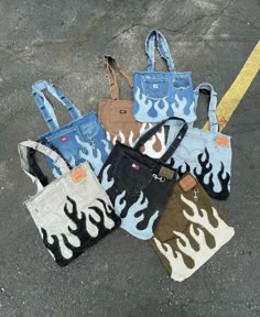 five purses with flames on them sitting in the middle of an empty parking lot