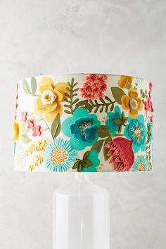 a lamp that is on top of a table with a flower print lampshade