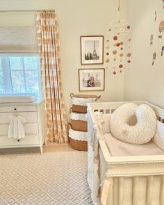 a baby's room with a crib, dresser and pictures on the wall