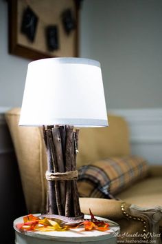 a lamp that is sitting on top of a table next to a plate with leaves