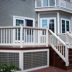 a house with white railings and steps leading up to the second story door area