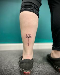 a woman's foot with a small flower tattoo on her left leg and the word love written in black ink