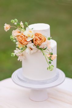 a white wedding cake with orange flowers on top and the words, i do like comment