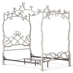 an iron bed frame with white flowers and branches on the headboard is made out of metal