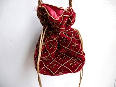 "Velvet evening purse with handwork of golden beads. Crossbody party bag with drawstring at the closure. It has an ethnic Indian touch in style and will go with western wears also like with dresses, jeans, etc. The bag is made up of velvet cloth in different color. It has a sling to hang it on the go. Can be used to gift some one or as fancy small sling bag in party or wedding. It can carry small things like mobile, wallet, etc. Dimension: maximum vertical length (of purse): 7\" vertical length Elegant Festival Bags For Festive Occasions, Elegant Festival Bags, Elegant Festive Bags For Festival, Festival Embroidered Evening Bag For Celebrations, Handwork Shoulder Bag For Celebrations, Festive Bohemian Shoulder Bag Gift, Celebration Handwork Shoulder Bag, Festival Clutch Shoulder Bag As Gift, Festival Clutch With Dori Work For Celebration