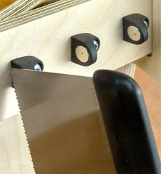 a close up of a knife on a table next to a board with holes in it