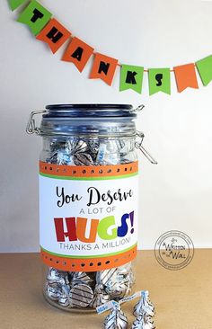 a jar filled with lots of candy sitting on top of a table next to a banner