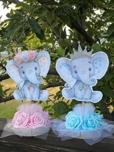 there are two little elephants that are sitting on the tree branch, one is wearing a tiara