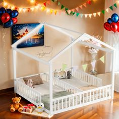 a white dollhouse bed in a room with balloons