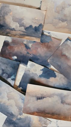 several pieces of watercolor paper with clouds on them