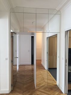 an empty room with mirrored walls and wooden floors