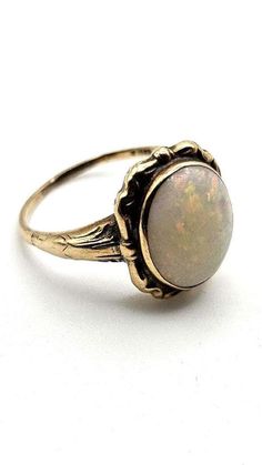 Big and beautiful oval white opal ring. The ring setting design is a subtle mid century style and the stone is bezel set. The opal measures 11x9.5mmx3 to 4mm deep, approximately 2 carats. Displays a lovely fire and colorplay. There are no readable marks on the ring but it was tested as 10k. Size 7.5. Expedited shipping is available by request on a case by case basis. Please message us if you require rush shipping. Returns are accepted within the time window noted. To recieve a full refund the re Victorian Gold Opal Ring Gift, Antique Hallmarked Opal Ring, Victorian Hallmarked Opal Ring, Victorian Yellow Gold Opal Cabochon Ring, Antique 14k Gold Opal Ring, Oval Cabochon, White Opal Ring, 2 Carat, White Opal, Mid Century Style