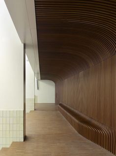 an empty hallway with wooden slats on the walls