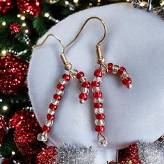 Sweet candy cane novelty earrings. Hand made with silver lined glass beads and mounted on gold plated ear wires. Available in red or gold. Approx drop 25 mm Holiday Red Beaded Earrings With Ear Wire, Red Beaded Drop Earrings For Christmas, Christmas Party Earrings With Round Beads, Christmas Party Round Bead Earrings, Christmas Party Round Beads Earrings, Christmas Party Earrings With Dangling Beads, Christmas Festive Gold Beaded Earrings, Gold Beaded Christmas Earrings, Festive Gold Beaded Christmas Earrings