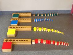 a group of wooden toys sitting on top of a gray floor next to each other