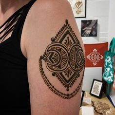 a woman with a tattoo on her arm that has an intricate design in the middle